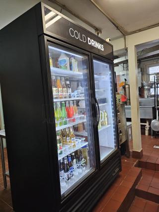 TRUE GDM-49 two-door refrigerator, tested and working, with glass doors displaying beverages, "Cold Drinks" sign above.