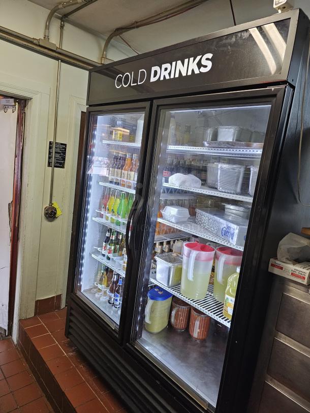 TRUE GDM-49 two-door refrigerator, tested and working, stocked with drinks and food items. Display reads "COLD DRINKS."