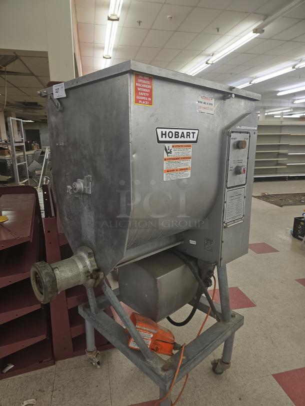 Hobart commercial vertical meat grinder & mixer, stainless steel, wear visible, safety warnings on unit.
