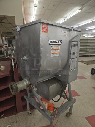 Hobart commercial vertical meat grinder & mixer, stainless steel, wear visible, safety warnings on unit.