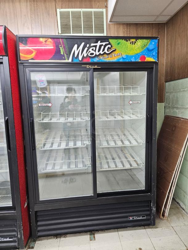 True GDM-45 glass door merchandiser with sliding doors, tested and working. Features include spacious interior, branded "Mistic" signage.
