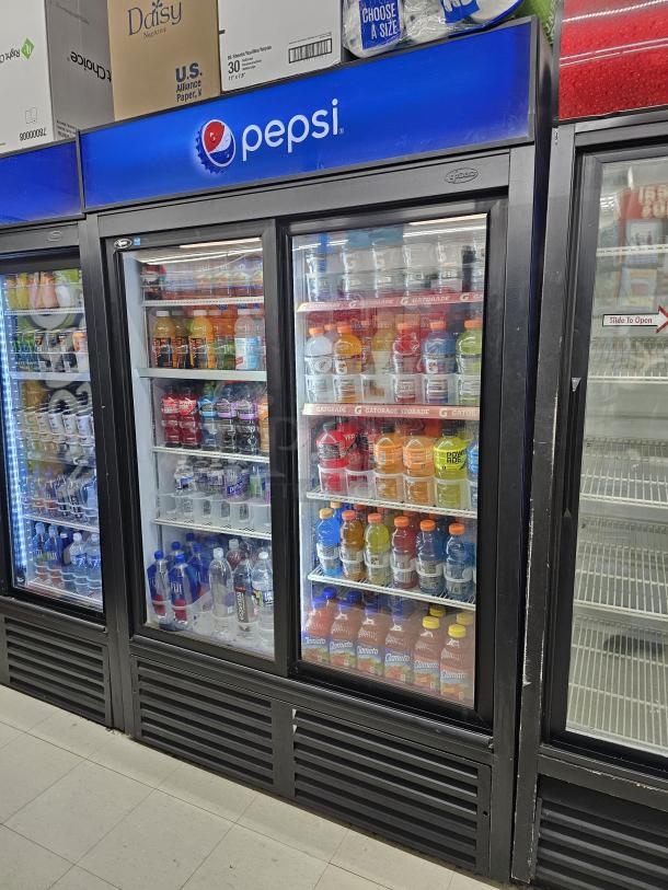 QBD CD45S two-door sliding glass merchandiser with Pepsi branding, stocked with beverages, tested and working.