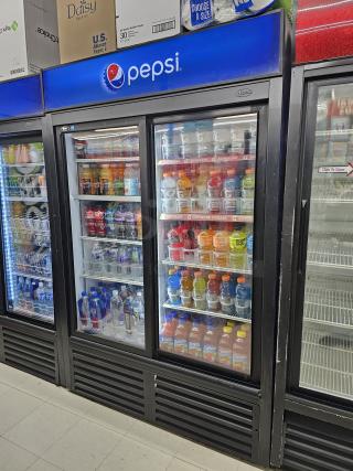 QBD CD45S two glass door sliding merchandiser, tested and working condition, branded Pepsi, shelves stocked with beverages.