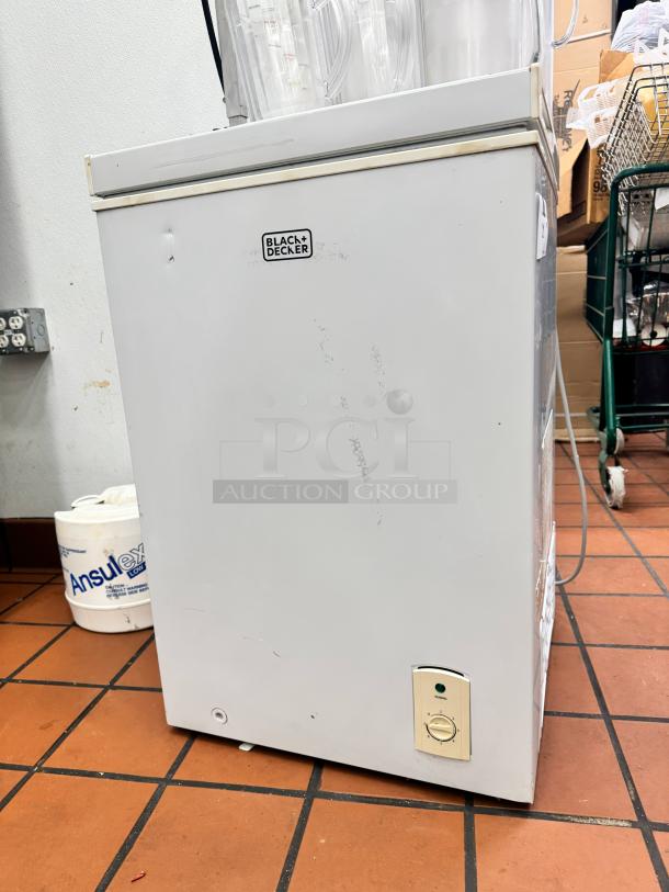 Black+Decker BCFK356 chest freezer, visible wear, temperature dial on front, logo on top, white finish.