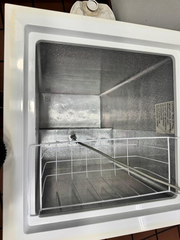 Black+Decker BCFK356 chest freezer, white interior, wire basket, label with safety caution, good condition.