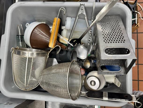 Bin of miscellaneous kitchenware including a grater, funnels, strainers, and utensils. Various conditions. All for one price.