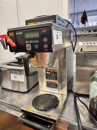 BUNN Commercial Coffee Brewer, model Axiom. Features digital controls, hot warning labels, used condition, auction lot tag.