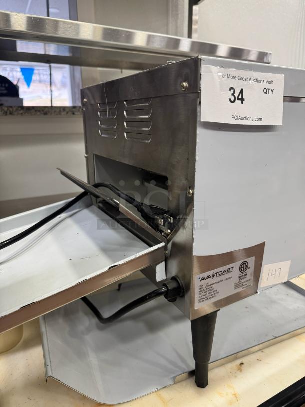 AvaToast CTA 7001 conveyor toaster, brand new, stainless steel, tabletop model with power cord, auction tag visible.