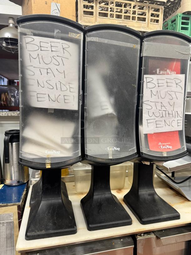 Lot of 3 EasyNap napkin dispensers, black, with humorous notes taped, used condition.