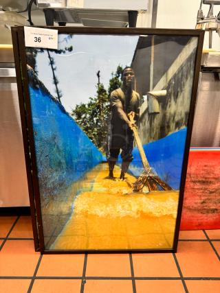 Framed art print BIDX3, depicting a man working in water, vibrant colors, in good condition, auction tag number 36.