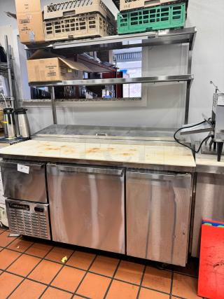 Continental 68" pizza prep-table with overhead shelf, stainless steel, tested and working, features storage and cutting surface.