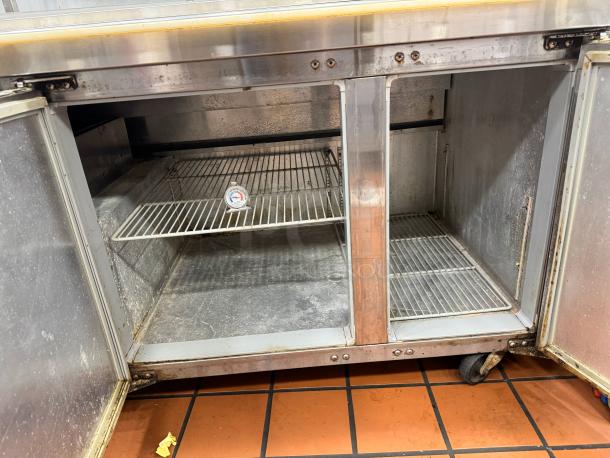 Continental 68" pizza prep-table with overhead shelf, stainless steel, double-door, tested and working, visible interior wire rack.