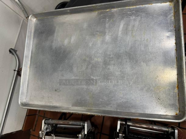 Set of 7 metal baking pans, used condition, showing scratches and wear. Ideal for commercial or home baking needs.