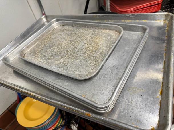 Lot of 7 metal baking pans, used condition, various sizes, visible wear and discoloration, sold as a single lot.