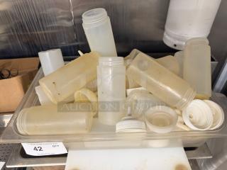 Lot of squeeze bottles in varying conditions. Includes caps and nozzles. Signs of use visible. Auction lot number 42.