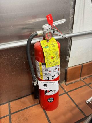 Red fire extinguisher with Pacific Fire label and maintenance tag. Includes instructions label and red tag marked "2022".