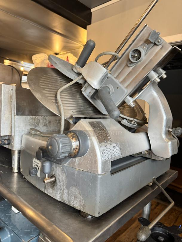 Hobart 2912 commercial meat slicer, showing metal body, adjustment knobs, and blade. Visible wear, model and safety labels.