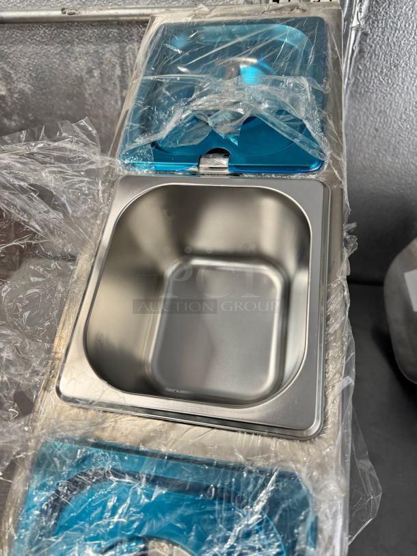 Stainless steel countertop condiment dispenser, brand new condition, with protective plastic wrap, featuring blue accents.