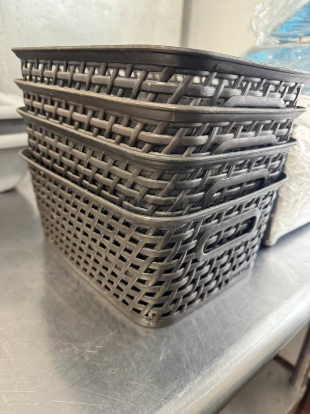 Lot of 4 small brown plastic weave bins, stackable, with built-in handles. Excellent condition. Ideal for storage.