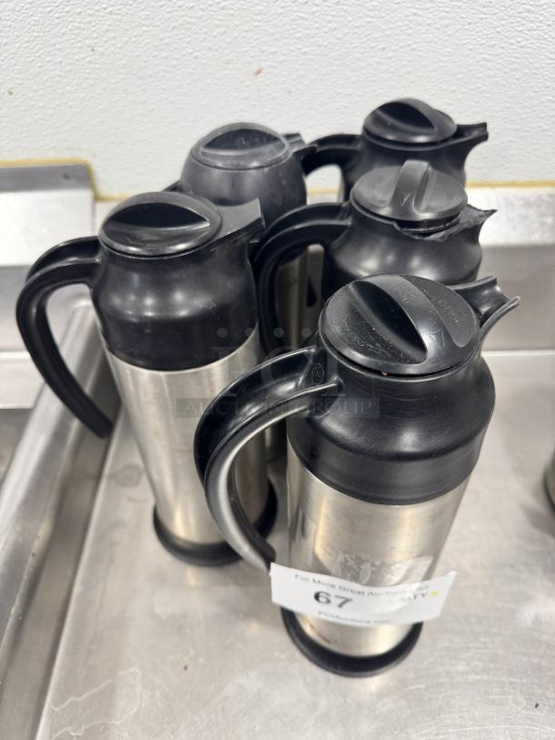 Stainless steel cream servers BIDX5, set of four, black plastic lids and handles, good condition, visible auction tag with lot number 67.