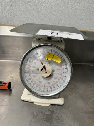 Vintage portion control scale with metal platform. Dial shows measurements in grams and ounces. Used condition with visible wear.