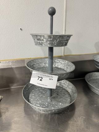 Three-tier galvanized tabletop serving tray with central handle, in good condition. Auction tag with item number 72 visible.