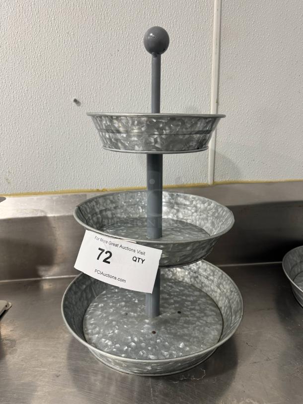 Three-tier galvanized tabletop serving tray, metallic finish, vertical rod with ball top, good condition, auction tag attached.