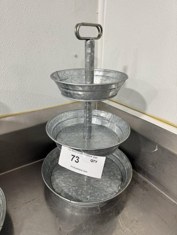 Galvanized three-tier tabletop serving tray with handle, excellent condition. Auction tag number 73 from PCIAuctions.com.