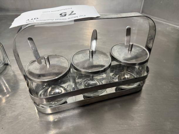 Stainless steel condiment caddy with three glass jars and lids, includes spoons, shows item number tag "76".