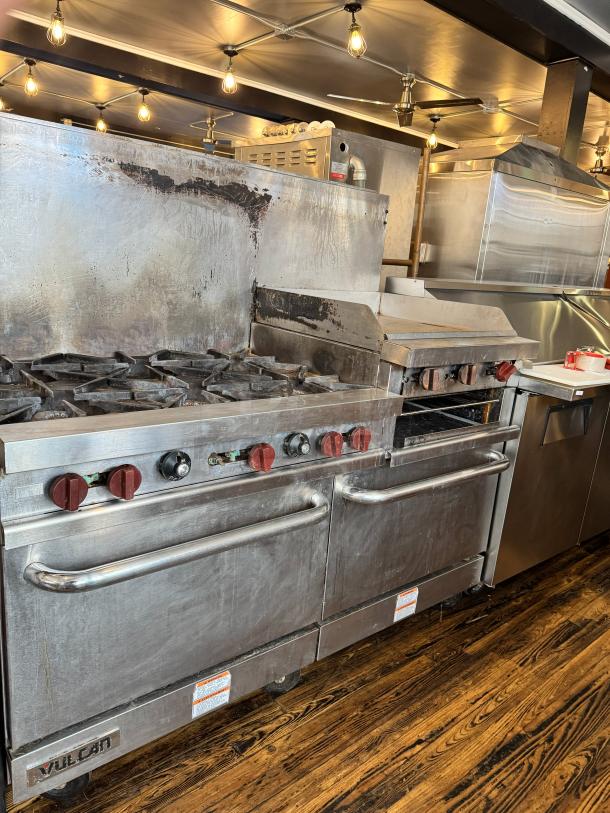 Vulcan 60" commercial gas range with griddle/broiler, two standard ovens, and visible brand logo. Good used condition.
