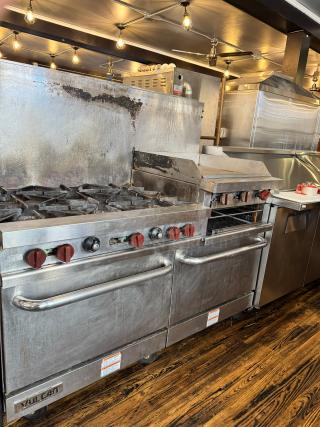 Vulcan 60" commercial gas range with griddle/broiler, two standard ovens, and visible brand logo. Good used condition.