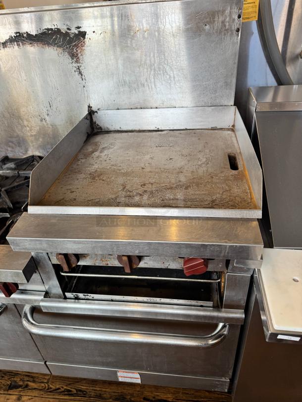 Vulcan 60" commercial gas range with griddle/broiler, two standard ovens; stainless steel; signs of wear; model details not visible.