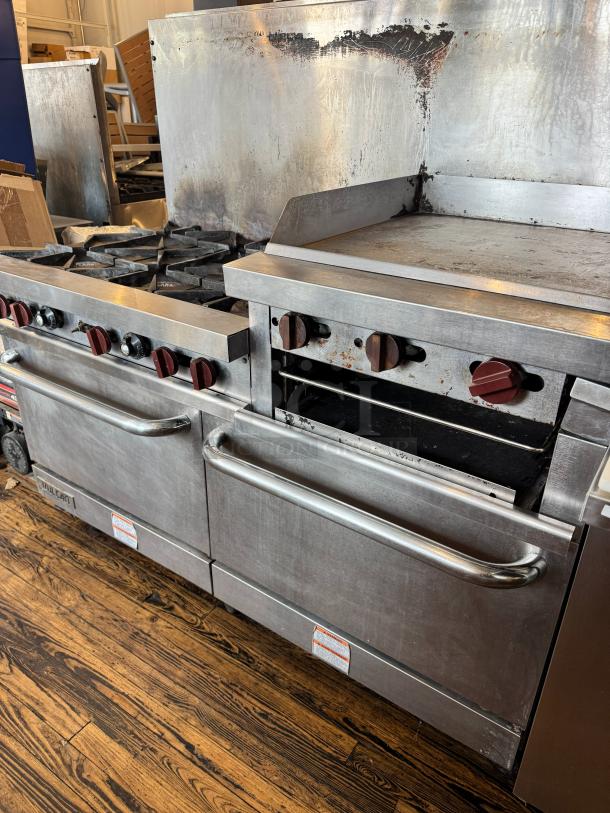 Vulcan 60" commercial gas range with griddle/broiler, two ovens. Stainless steel with control knobs. Used condition.