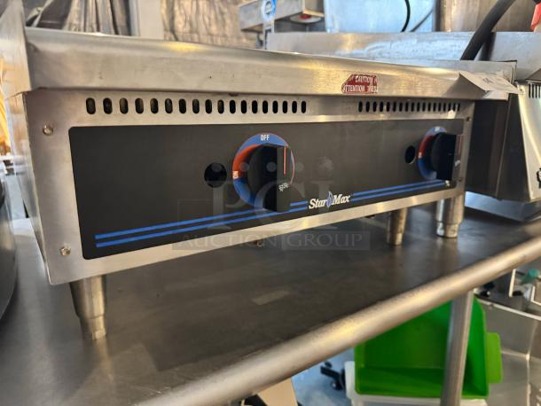 Star Max 24" natural gas commercial griddle; stainless steel, control knobs visible, slight wear, "Caution" label affixed.
