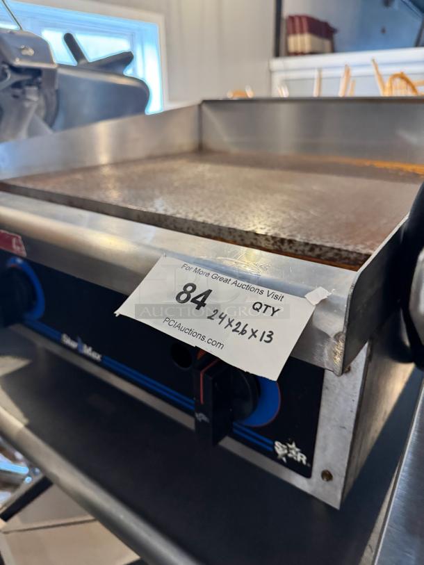 Star Max 24" natural gas commercial griddle, stainless steel. Visible auction tag, dimensions 24x26x13 inches, good condition.