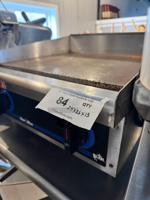Star Max 24" natural gas commercial griddle, stainless steel, features temperature control knobs. Slight wear visible.