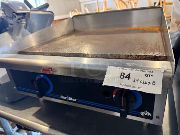 Star Max 24" commercial griddle, natural gas, features dual knobs, stainless steel surface. Auction tag shows dimensions 24x26x13.