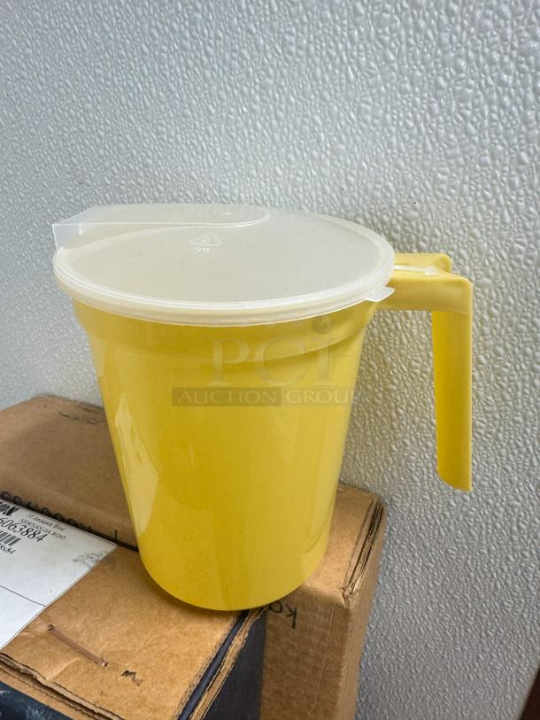 32oz yellow plastic pitcher with lid, model BIDX40, in good condition. Features an easy-grip handle.
