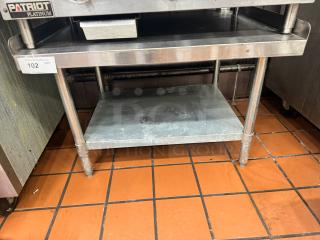 36" stainless steel stand with two shelves, sturdy legs, minor surface wear, label "Patriot Platinum." Suitable for commercial use.