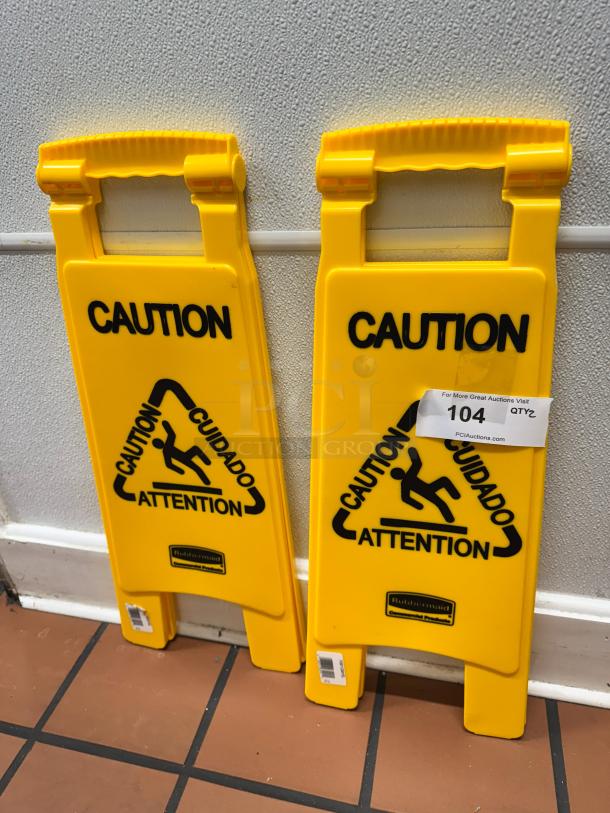 Yellow Rubbermaid Commercial Products floor signs with "Caution" text in multiple languages, in good condition.