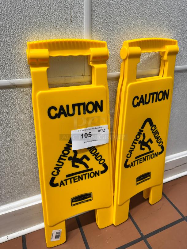 Two yellow Rubbermaid Commercial Products folding floor signs, labeled "CAUTION WET FLOOR," in excellent condition.