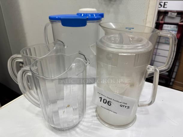 Set of transparent plastic pitchers, various designs, with 106 QTY5 auction label, used condition.