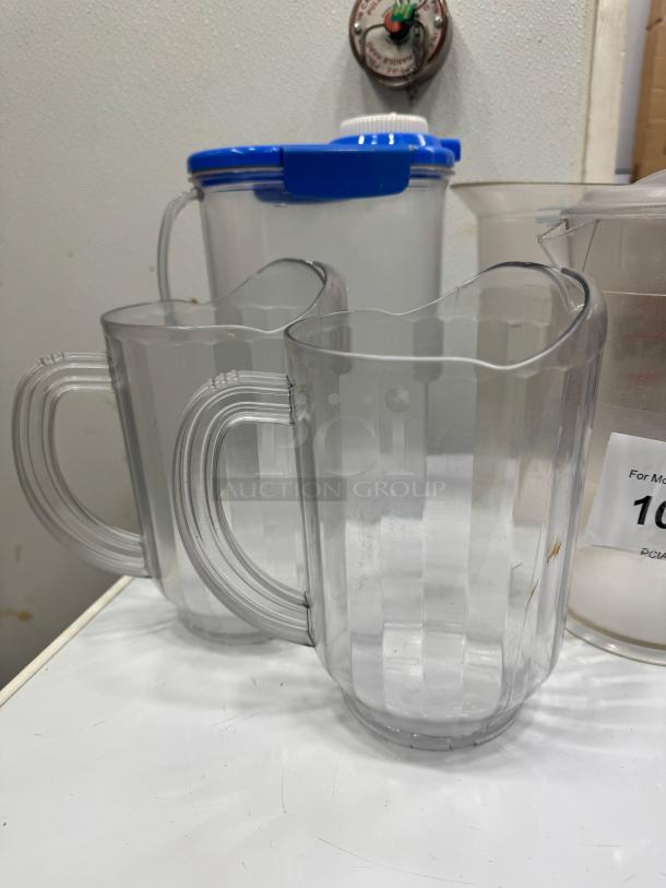 Clear plastic pitcher BIDX5, sturdy handle, fluted design, excellent condition, ideal for serving beverages.