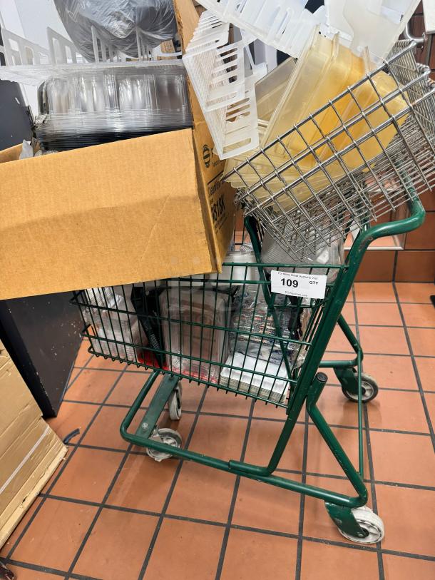 Green metal shopping cart filled with various plastic containers and a cardboard box. Auction tag shows "109" and "QTY".