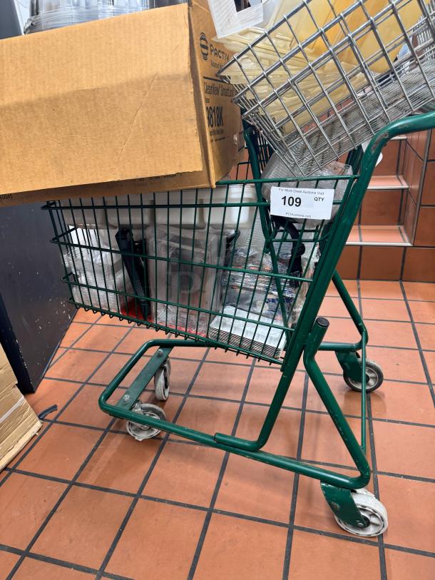 Green shopping cart filled with assorted items, including a cardboard box and metal rack. Auction tag reads "109 QTY".