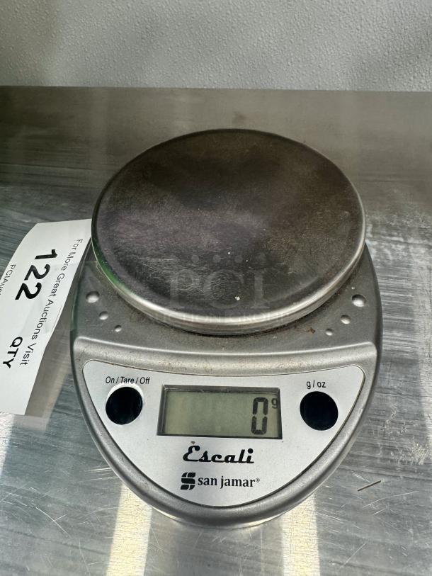 San Jamar Digital Scale, silver, LCD display showing 0g, on/tare button, in used condition, ideal for precise measurements.
