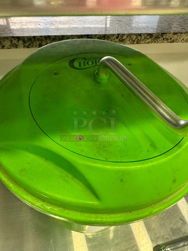 Green Choice salad spinner with stainless steel handle; visible wear, embossed Choice logo on lid.