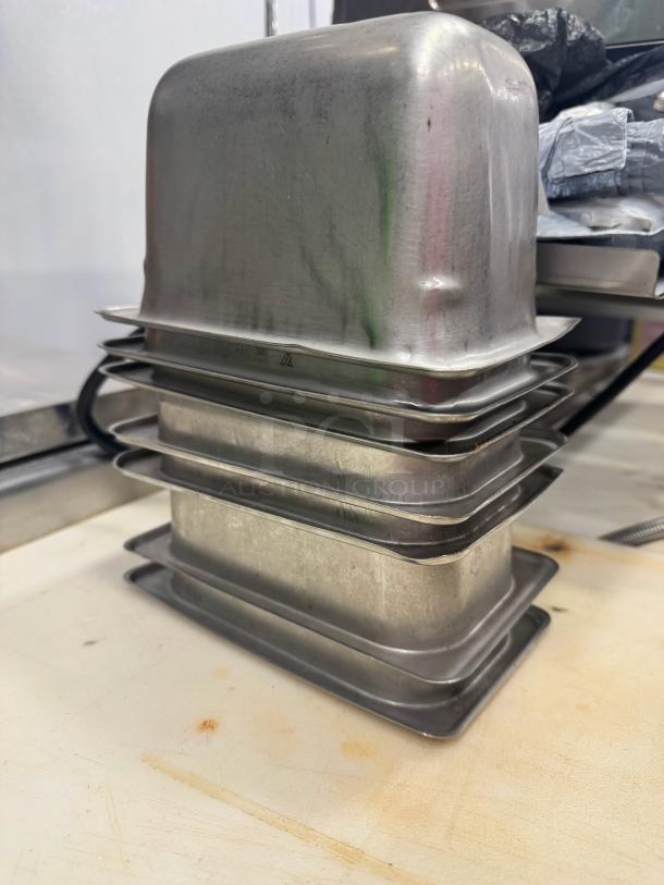 Stainless steel food pan BIDX7, stackable, rectangular, excellent condition, no visible markings.