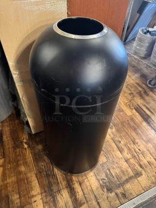 Black open top trash can with a metallic rim, in good condition, cylindrical shape. No visible labels.