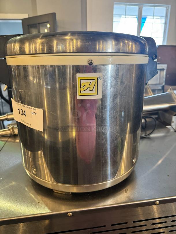 Stainless steel rice warmer, 50-cup capacity, brand logo visible. Item tag marked "134 QTY". Appears in good condition.
